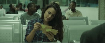 Movie still from “Palm Trees in the Snow” (2015), directed by Fernando González Molina – A woman sitting on a bench looking at a piece of paper; Close Up shot, Over the shoulder angle