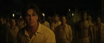 Movie still from “Palm Trees in the Snow” (2015), directed by Fernando González Molina – A group of men in yellow shirts standing next to each other; Close Up shot, Low angle