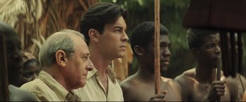 Movie still from “Palm Trees in the Snow” (2015), directed by Fernando González Molina – A group of men standing next to each other; Medium shot, Over the shoulder angle