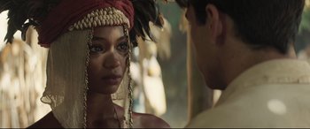 Movie still from “Palm Trees in the Snow” (2015), directed by Fernando González Molina – A woman wearing a headdress with a man standing next to her; Close Up shot, Over the shoulder angle