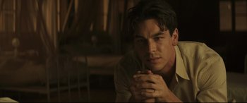 Movie still from “Palm Trees in the Snow” (2015), directed by Fernando González Molina – A person with his hand on his chin; Close Up shot, Over the shoulder angle