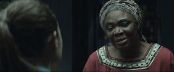 Movie still from “Palm Trees in the Snow” (2015), directed by Fernando González Molina – An older woman is looking at a young man; Close Up shot, Over the shoulder angle