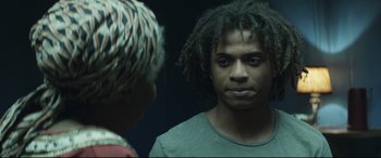 Movie still from “Palm Trees in the Snow” (2015), directed by Fernando González Molina – A young man with dreadlocks looking into a mirror; Close Up shot, Over the shoulder angle