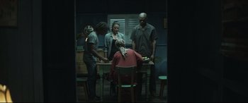 Movie still from “Palm Trees in the Snow” (2015), directed by Fernando González Molina – A group of people standing around a table; Wide shot, Over the shoulder angle
