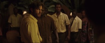 Movie still from “Palm Trees in the Snow” (2015), directed by Fernando González Molina – A group of men standing next to each other; Medium shot, Over the shoulder angle