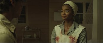 Movie still from “Palm Trees in the Snow” (2015), directed by Fernando González Molina – A woman in a white apron with blood on her face; Close Up shot, Over the shoulder angle