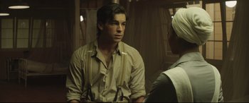 Movie still from “Palm Trees in the Snow” (2015), directed by Fernando González Molina – A man sitting in front of another man; Medium shot, Over the shoulder angle