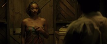 Movie still from “Palm Trees in the Snow” (2015), directed by Fernando González Molina – A woman standing in front of a bathroom mirror; Medium shot, Over the shoulder angle