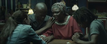 Movie still from “Palm Trees in the Snow” (2015), directed by Fernando González Molina – An older woman sitting at a table with a younger man; Medium shot, Over the shoulder angle