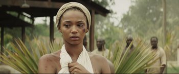 Movie still from “Palm Trees in the Snow” (2015), directed by Fernando González Molina – A woman with a bandage around her neck; Close Up shot, Over the shoulder angle