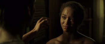 Movie still from “Palm Trees in the Snow” (2015), directed by Fernando González Molina – A woman looking into a mirror while holding her hand up; Close Up shot, Over the shoulder angle