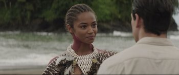 Movie still from “Palm Trees in the Snow” (2015), directed by Fernando González Molina – A young woman wearing a necklace of shells and feathers; Close Up shot, Over the shoulder angle