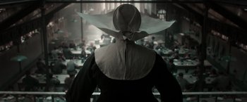 Movie still from “Pan” (2015), directed by Joe Wright – A woman wearing a hat standing in front of a window; Medium shot, High angle