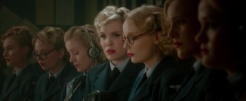 Movie still from “Pan” (2015), directed by Joe Wright – A group of women in military uniforms listening to music; Close Up shot, Over the shoulder angle