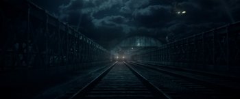 Movie still from “Pan” (2015), directed by Joe Wright – A train on the train tracks in a dark place; Extreme Wide shot, Low angle