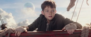 Movie still from “Pan” (2015), directed by Joe Wright – A young boy leaning on a fence looking at the sky; Close Up shot, Low angle