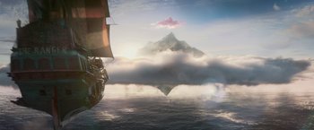 Movie still from “Pan” (2015), directed by Joe Wright – An image of a boat in the water with a mountain in the background; Extreme Wide shot, Low angle