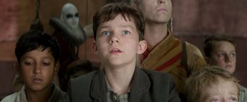 Movie still from “Pan” (2015), directed by Joe Wright – A young boy with blue eyes looking up at the sky; Close Up shot, Low angle