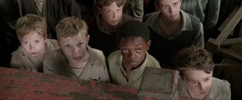 Movie still from “Pan” (2015), directed by Joe Wright – A group of young men standing next to each other; Medium shot, High angle