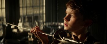 Movie still from “Pan” (2015), directed by Joe Wright – A young boy holding a pair of scissors in his hands; Close Up shot, Low angle