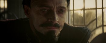Movie still from “Pan” (2015), directed by Joe Wright – A person with a beard and a mustache; Close Up shot, Over the shoulder angle