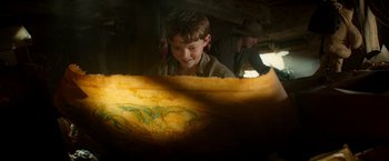 Movie still from “Pan” (2015), directed by Joe Wright – A young boy is looking at a map; Close Up shot, High angle