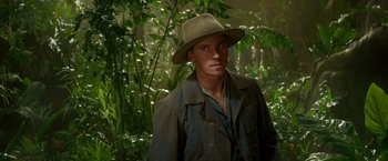 Movie still from “Pan” (2015), directed by Joe Wright – A man wearing a hat standing in the woods; Close Up shot, Over the shoulder angle