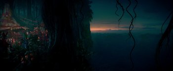 Movie still from “Pan” (2015), directed by Joe Wright – A view of a forest at night with a sky filled with clouds; Extreme Wide shot, High angle