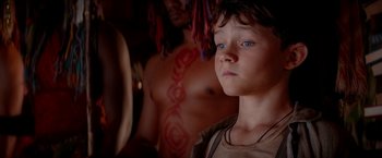 Movie still from “Pan” (2015), directed by Joe Wright – A young boy standing in front of a shirtless man; Close Up shot, Over the shoulder angle