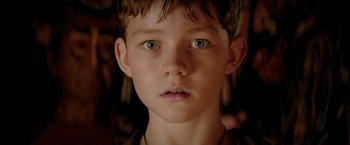 Movie still from “Pan” (2015), directed by Joe Wright – A young boy's face with green eyes; Close Up shot, Low angle