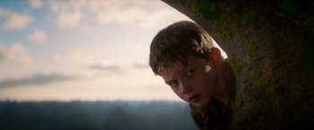 Movie still from “Pan” (2015), directed by Joe Wright – A young boy is looking over a ledge; Close Up shot, Low angle