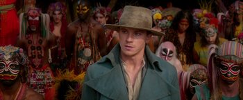 Movie still from “Pan” (2015), directed by Joe Wright – A man wearing a hat standing in front of a group of people; Close Up shot, Over the shoulder angle