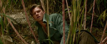 Movie still from “Pan” (2015), directed by Joe Wright – A man in a green jacket in the grass; Close Up shot, Low angle