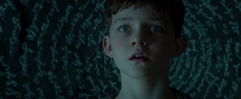 Movie still from “Pan” (2015), directed by Joe Wright – A young boy with blue eyes stares into the distance; Close Up shot, Overhead angle