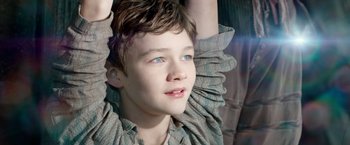 Movie still from “Pan” (2015), directed by Joe Wright – A young boy with blue eyes looking upward; Close Up shot, High angle