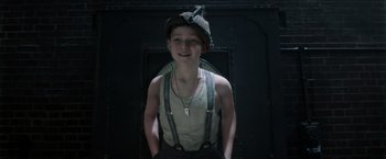 Movie still from “Pan” (2015), directed by Joe Wright – A young man wearing suspenders and a hat; Medium shot, Low angle