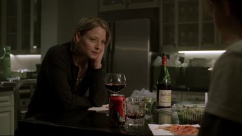 Movie still from “Panic Room” (2002), directed by David Fincher – A woman sitting at a table with a glass of red wine; Medium shot, Over the shoulder angle