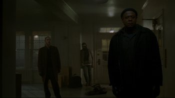 Movie still from “Panic Room” (2002), directed by David Fincher – A group of people standing in a room; Wide shot, Low angle