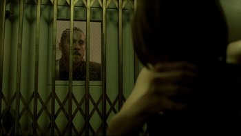 Movie still from “Panic Room” (2002), directed by David Fincher – A man is looking out of a jail cell window; Close Up shot, Over the shoulder angle