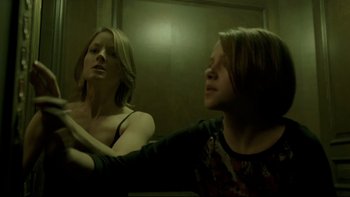 Movie still from “Panic Room” (2002), directed by David Fincher – A woman looking in the mirror in front of a mirror; Medium shot, Low angle