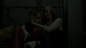 Movie still from “Panic Room” (2002), directed by David Fincher – A woman and a boy sitting next to each other; Medium shot, Low angle