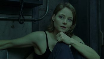 Movie still from “Panic Room” (2002), directed by David Fincher – A woman sitting on the ground with her hand on her chin; Close Up shot, High angle