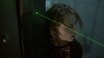Movie still from “Panic Room” (2002), directed by David Fincher – A young girl with a green laser beam in her eye; Close Up shot, Over the shoulder angle