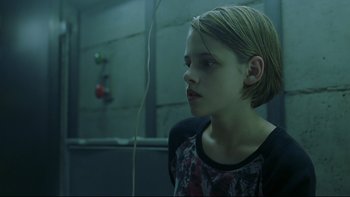 Movie still from “Panic Room” (2002), directed by David Fincher – A young girl is standing in a dark room; Medium shot, Over the shoulder angle