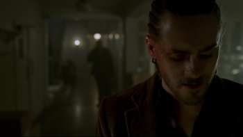 Movie still from “Panic Room” (2002), directed by David Fincher – A man in a brown shirt is in a dark room; Close Up shot, Over the shoulder angle