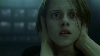 Movie still from “Panic Room” (2002), directed by David Fincher – A young girl with her hand to her ear; Close Up shot, Low angle