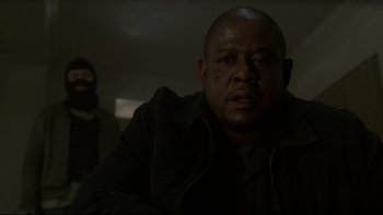 Movie still from “Panic Room” (2002), directed by David Fincher – A man in a dark room looking at the camera; Close Up shot, Low angle