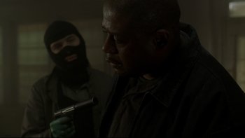 Movie still from “Panic Room” (2002), directed by David Fincher – A man holding a gun while another man looks on; Close Up shot, Low angle