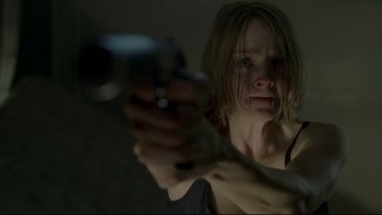 Movie still from “Panic Room” (2002), directed by David Fincher – A woman is holding a gun in a dark room; Close Up shot, Over the shoulder angle