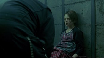Movie still from “Panic Room” (2002), directed by David Fincher – A girl sitting on the ground in a dark room; Medium shot, Over the shoulder angle